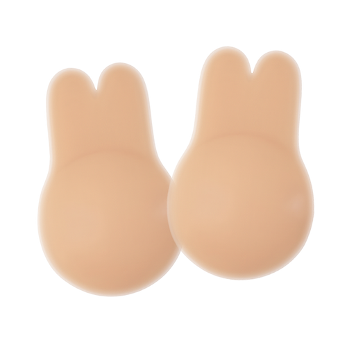 Pair of nude-colored Boob Bunnies breast lift pads with a bunny-ear shaped top and rounded base, made from smooth silicone material. Displayed on a transparent background with a subtle shine highlighting their soft, skin-like texture.